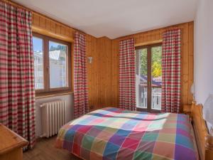 a bedroom with a bed and two windows at Residenza 3-Tre in Madonna di Campiglio