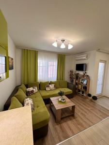 a living room with a green couch and a table at Апартамент "ИЛИЕВИ" in Obzor +23 photos