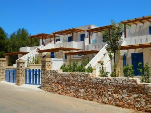 een gebouw met een stenen muur en een hek bij Il Carrubo Martella in Gagliano del Capo