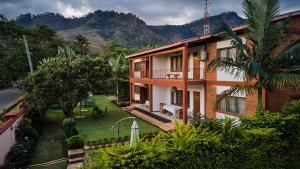 an image of a house with mountains in the background at Mango Lodge Zomba in Zomba