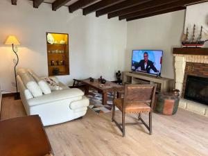 Longère sur Loire : غرفة معيشة مع أريكة بيضاء وتلفزيون