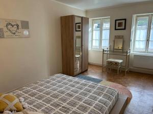 um quarto com uma cama, uma cómoda e janelas em Longère sur Loire 