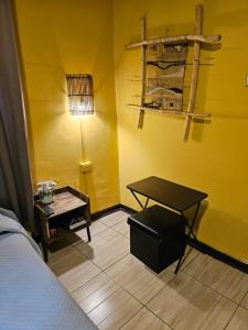 um quarto com uma cama, uma mesa e um candeeiro em Hostal Pucara Molina em Molina