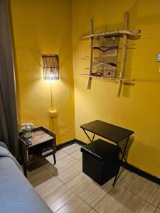 um quarto com uma cama, uma mesa e um candeeiro em Hostal Pucara Molina em Molina