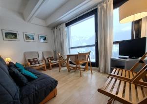 ein Wohnzimmer mit einem Sofa und einem Tisch mit Stühlen in der Unterkunft Résidence Cassiopée - maeva Home - Studio 4 personnes - Budget 53 in Arâches-la-Frasse