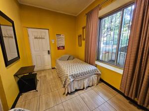 a bedroom with a bed in a room with yellow walls at Hostal Pucara Molina in Molina