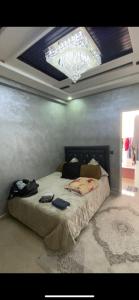 a bedroom with a large bed with a ceiling at Appartement Hay salam in Agadir