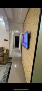 a living room with a television on a wall at Appartement Hay salam in Agadir