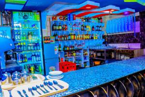 a bar with a blue counter with bottles of alcohol at Malibu Lounge Bar & Restaurant in Kisii