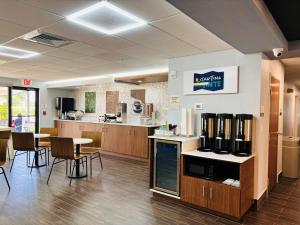 a kitchen with tables and chairs and a counter at Sleep Inn & Suites Lakeland I-4 in Lakeland