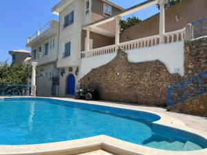 une grande piscine en face d'un bâtiment dans l'établissement Mille ou une nuit, à Tunis