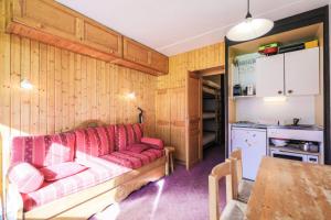 ein Wohnzimmer mit einem roten Sofa und einer Küche in der Unterkunft Résidence Antarès - maeva Home - Studio 4 Personnes - Budget 62 in Flaine