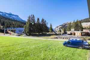 a blue van parked in a field next to a road at Résidence Antarès - maeva Home - Studio 4 Personnes - Budget 62 in Flaine