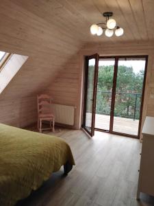 a bedroom with a bed and a large window at Sosnogródek in Rutka Tartak