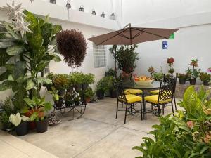 a patio with a table and chairs and potted plants at El Rincon de Los Angeles in Colima