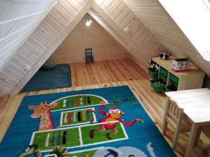 a attic room with a rug on the floor at Sosnogródek in Rutka Tartak
