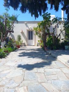 a stone walkway leading to a house with a door at Maria's garden house in Archangelos