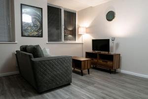 een woonkamer met een bank en een televisie bij Manchester 1Bed Apartment, Free Parking For Two, Long Term Discounts in Manchester