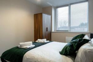 een slaapkamer met een groot bed met groene lakens bij Manchester 1Bed Apartment, Free Parking For Two, Long Term Discounts in Manchester