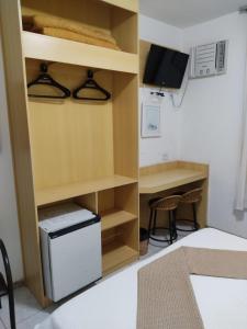 Habitación con escritorio pequeño y nevera pequeña. en Pousada do Garimpo, en Diamantina