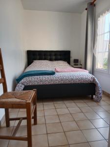 um quarto com uma cama, uma cadeira e uma janela em Les Hortensias em Challans