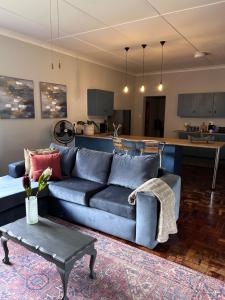 巴莉斯的住宿－Lilibeth guesthouse，客厅配有蓝色的沙发和桌子