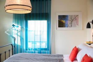 sypialnia z niebieskimi zasłonami i łóżkiem z oknem w obiekcie Modja Modja House w mieście Kent