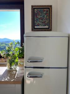 a refrigerator in a kitchen with a table and a picture at Mirando a Corona in Ayuela