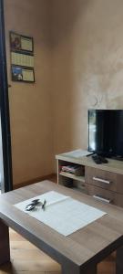 ein Wohnzimmer mit einem Tisch und einem TV in der Unterkunft Apartman Miletić 4 in Zlatibor