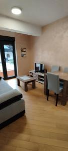 ein Wohnzimmer mit einem Sofa, einem Tisch und einem TV in der Unterkunft Apartman Miletić 4 in Zlatibor