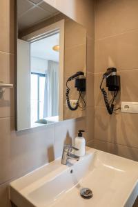 a bathroom with a sink and a mirror at Hostal Alicante in San Antonio