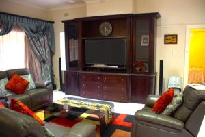a living room with couches and a flat screen tv at 9 Spitfire in Benoni