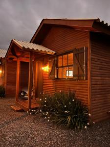 Cabaña de madera con porche y ventana en Pousada Costaneira en Cambará