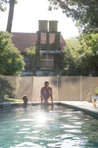 un hombre arrodillado en una piscina en Baden Baden Carilo en Cariló