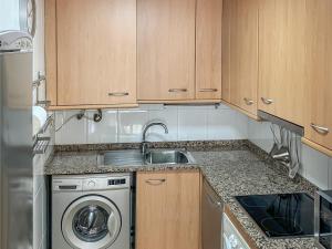 a kitchen with a sink and a washing machine at Apartamento Port Marino in Cambrils