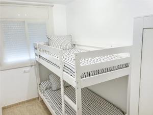 カンブリルスにあるApartamento Port Marinoの白い部屋の白い二段ベッド