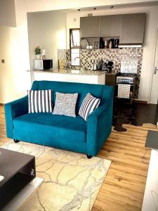 um sofá azul numa sala de estar com uma cozinha em Quiet Nest Homes em Tatu City