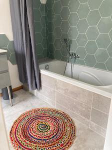 ein Badezimmer mit einer Badewanne und einem Teppich in der Unterkunft Appart Pro & Famille in Verdun-sur-Meuse + 9 Fotos