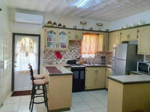 a kitchen with a stove and a refrigerator at 1-bedroom suburban apartment with free parking in Kingstown
