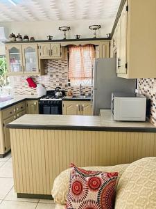 una cucina con piano di lavoro e piano cottura forno superiore di 1-bedroom suburban apartment with free parking a Kingstown