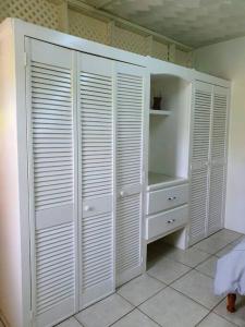 a white closet with white closets in a room at 1-bedroom suburban apartment with free parking in Kingstown