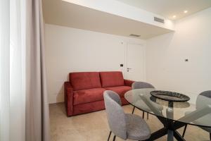 sala de estar con sofá rojo y mesa de cristal en I Due Mori - Luxury Rooms en Giardini Naxos