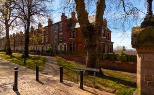 un panneau devant un arbre devant un bâtiment dans l'établissement Limpenny Studio - Cityscape Cozy Corner, à Nottingham