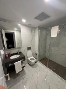 a bathroom with a shower and a toilet and a sink at Grand Sapphire Resort 1+1 İskele in Iskele