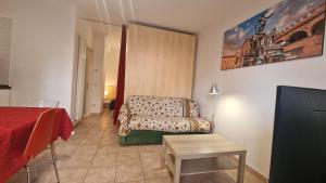 Un dormitorio con una cama, un sofá y una mesa. en Fiorilli House - Fair District - Gratis Private Parking, en Bolonia