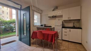 a kitchen with a table with a red table cloth at Fiorilli House - Fair District - Gratis Private Parking in Bologna