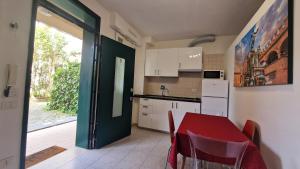 cocina con mesa roja y cocina con puerta en Fiorilli House - Fair District - Gratis Private Parking, en Bolonia 9 fotos más