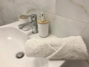 un lavandino in bagno con un asciugamano bianco di Ella apartment a Timişoara Altre 29 foto