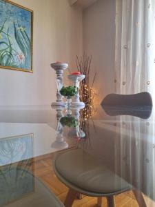 a glass table with three glass vases on top of it at Cozy apartment next to metro station in Athens