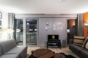 una sala de estar con un sofá y una mesa en Résidence La Petite Ourse - maeva Home - Studio 3 Personnes - Sélection MAE-4901, en Arâches-la-Frasse